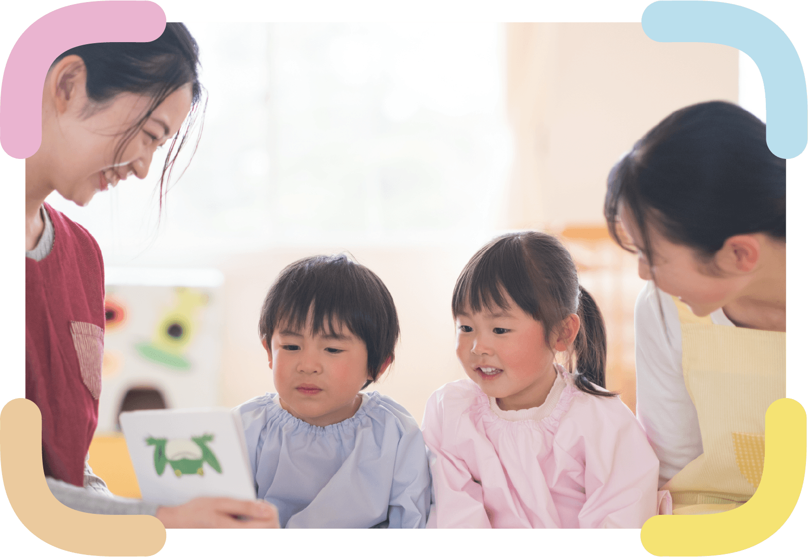 保育園で保育士と子どもが遊んでいる様子の写真