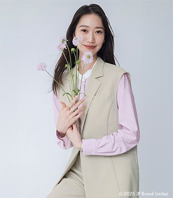 ピンク×ベージュの服を着用している女性