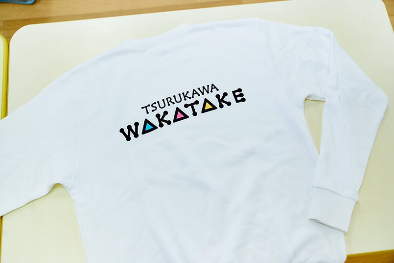 トレーナーは背中に大きくロゴマークをプリント